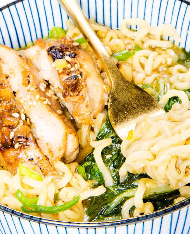 a close up image of a bowl of Miso Ramen soup with a fork twirling the noodles