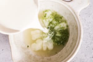 The wet ingredients in a bowl with milk being poured in.