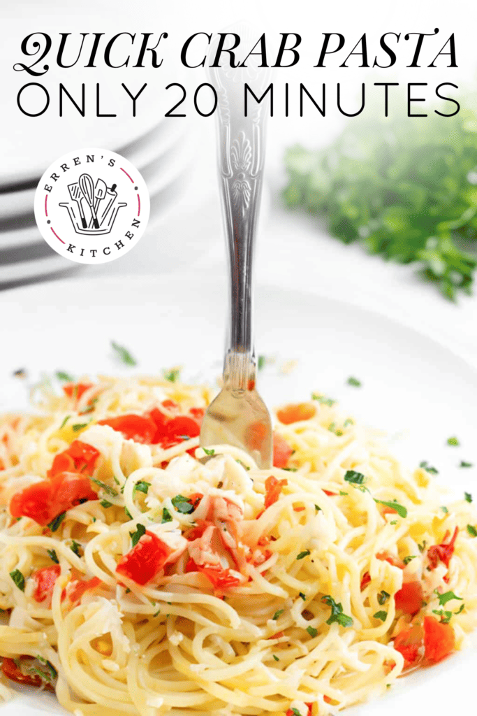 A delicious plate of spaghetti and crab with red piquante peppers being twisted onto a fork with parsley sprinkled on top.