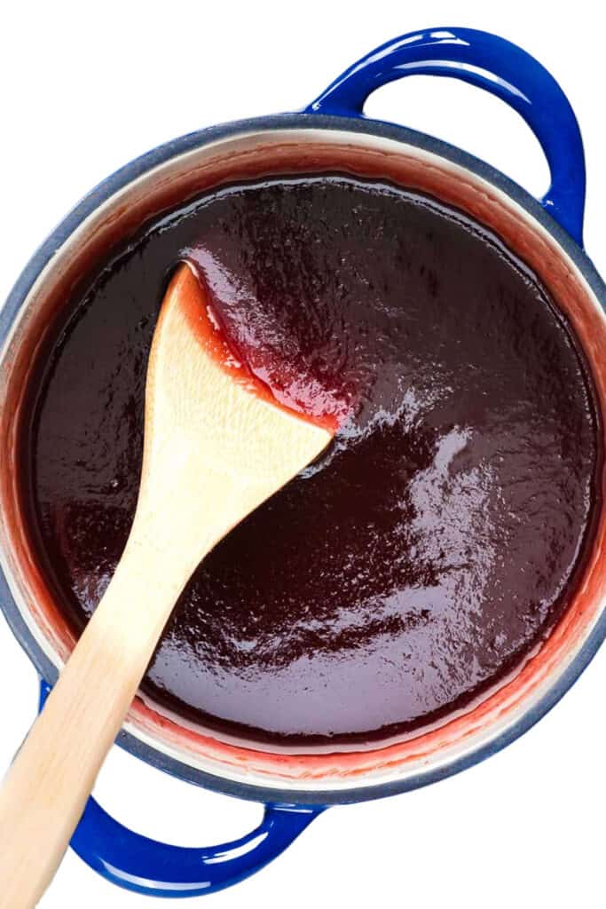 the reduced Carolina BBQ sauce in a pan with a wooden spoon