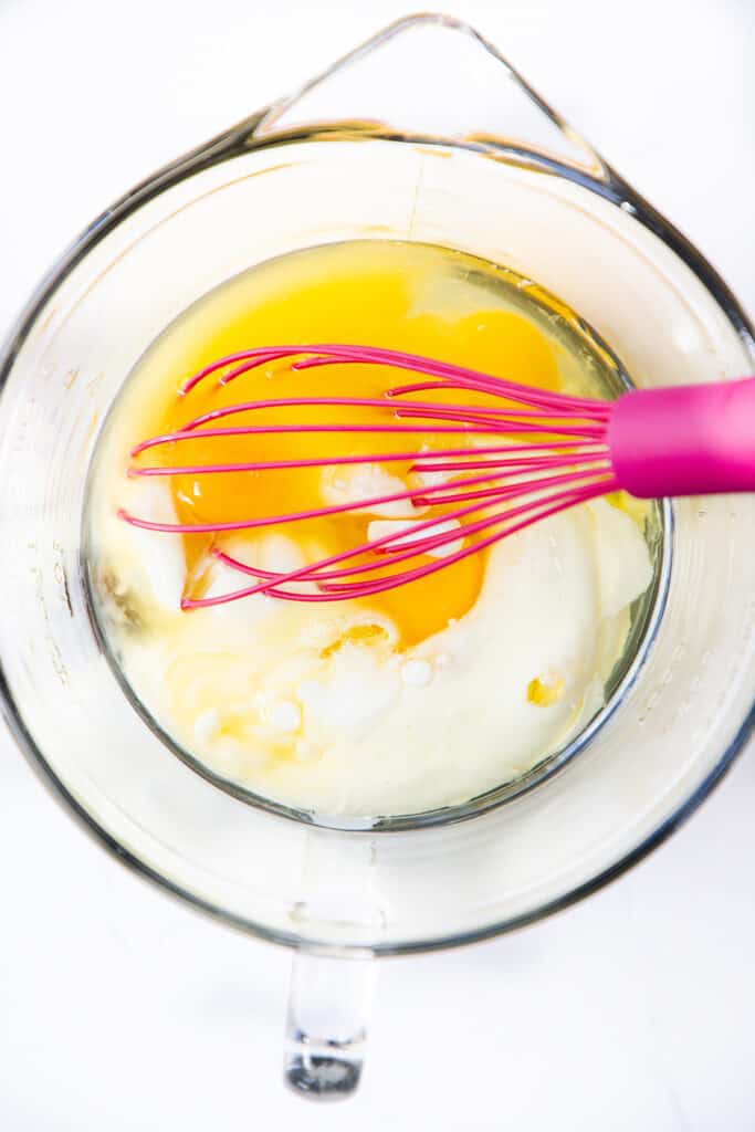 the wet ingredients for the Blueberry Pancakes in a bowl with a whisk