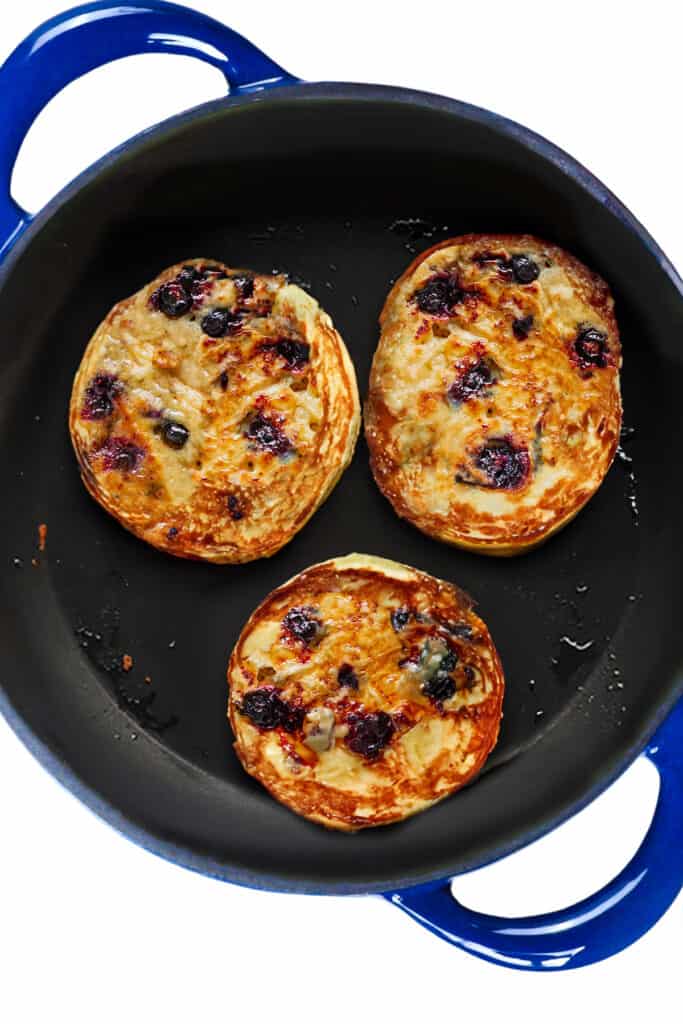 the flipped, golden Blueberry Pancakes in the pan