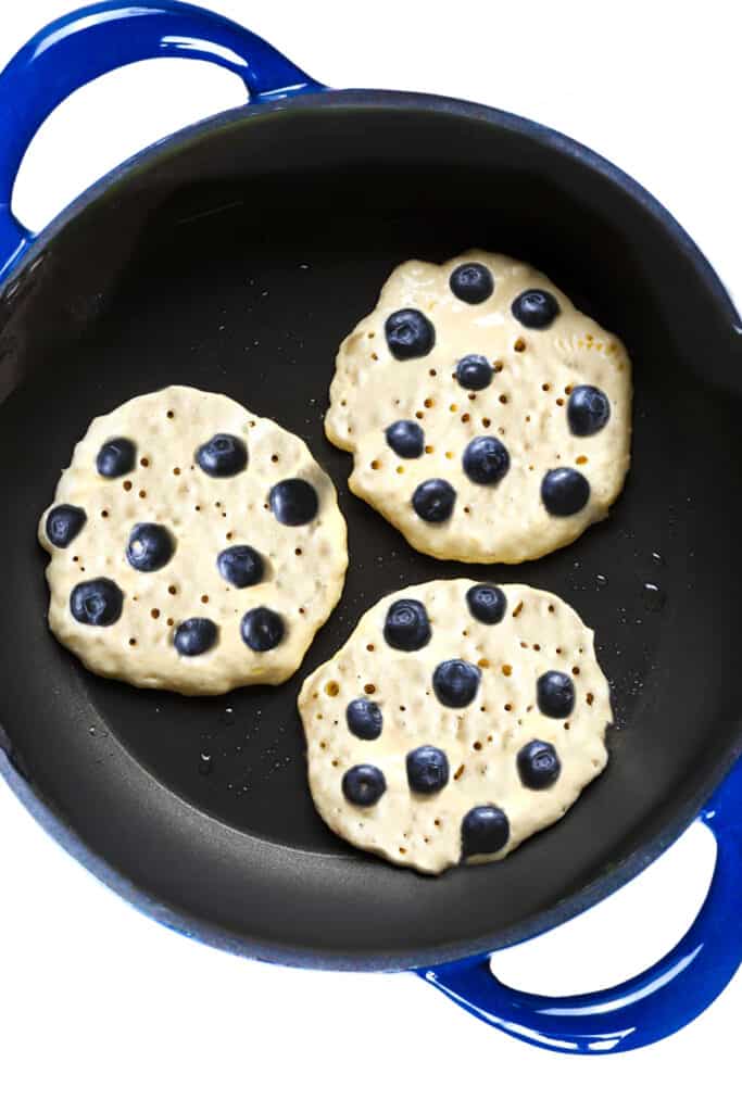 the blueberry pancakes with popped bubbles on the surface