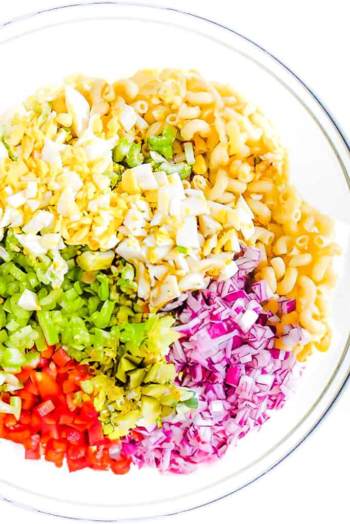 all of the ingredients for the Macaroni Salad in a glass bowl