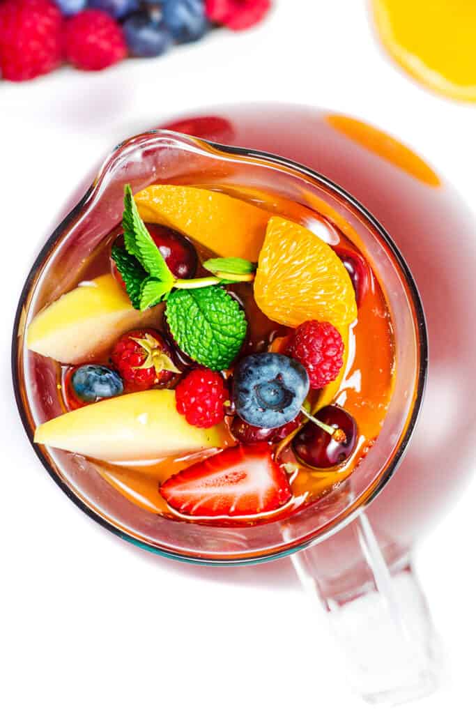 an overhead image of a pitcher of Rosé Sangria with berries and sliced citrus fruits