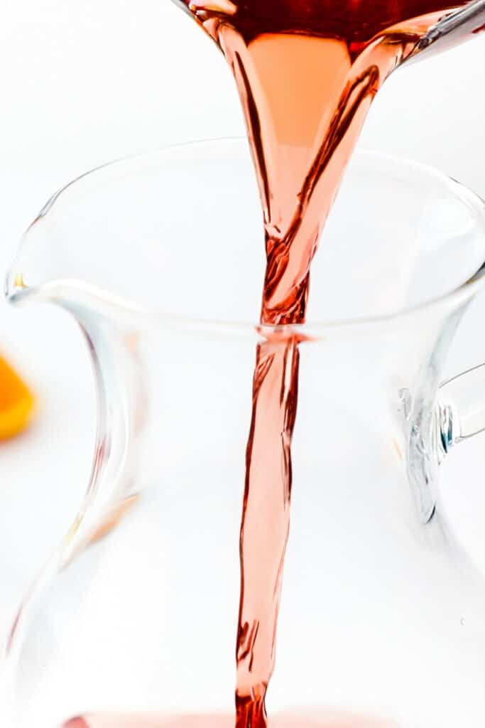 Rosé wine being poured into a jug for Rosé Sangria