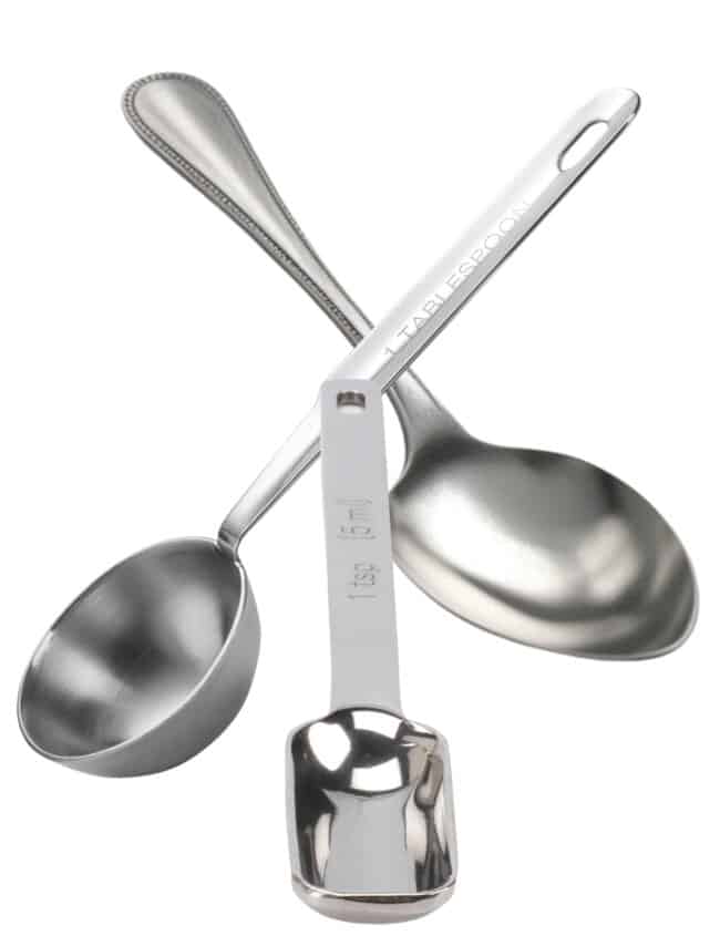 a stainless steel tablespoon and teaspoon measuring spoon and a dessert spoon with a white background