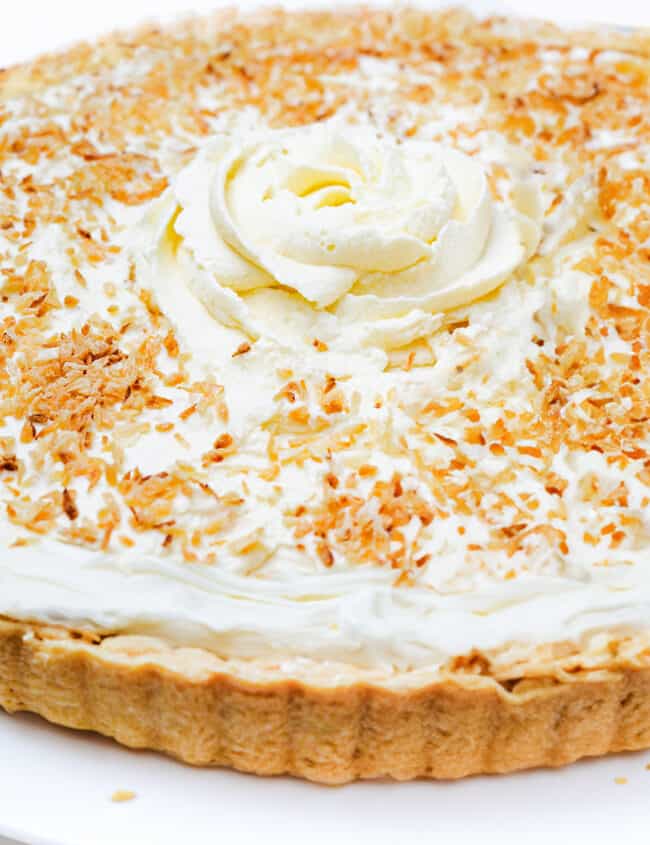 a full image of the coconut cream pie on a plate with a pie server next to it.