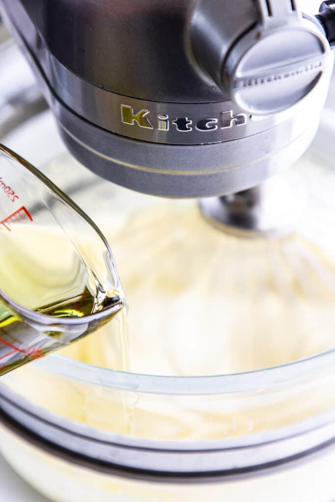 the oil being poured into the egg and sugar mixture for the lemon curd cake.