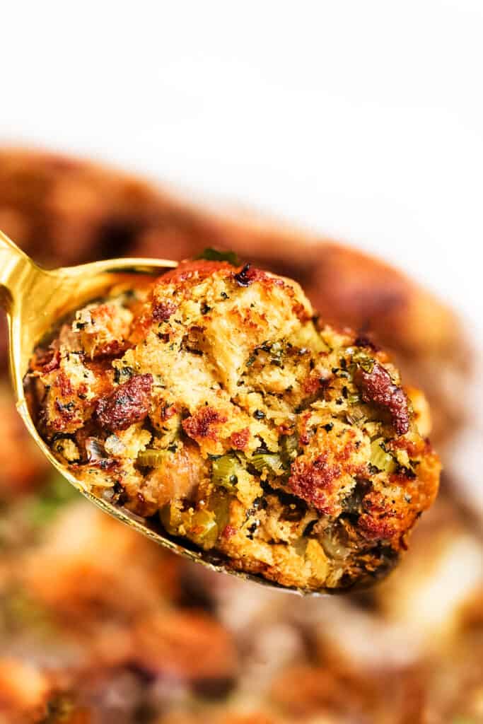 a close up image of spoonful of sausage stuffing being served.