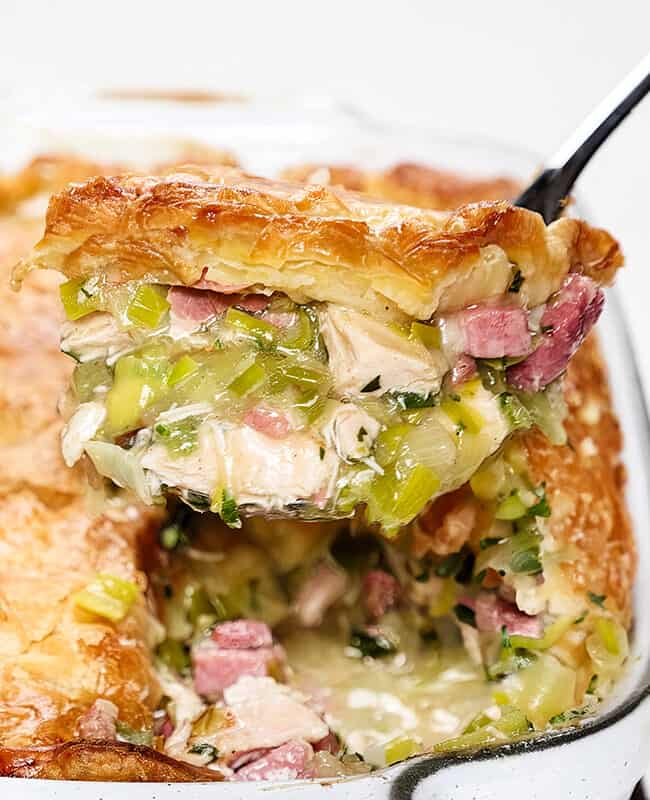 a serving spoon over the turkey and Ham pie with a scoop of the pie in the spoon