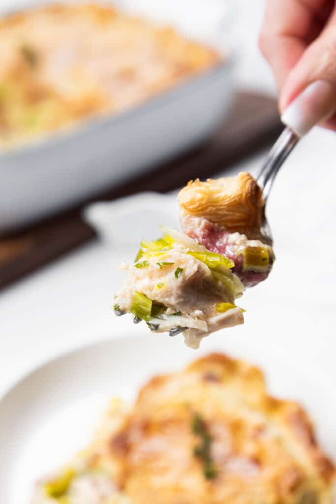 Close up of a forkful of turkey and ham pie.