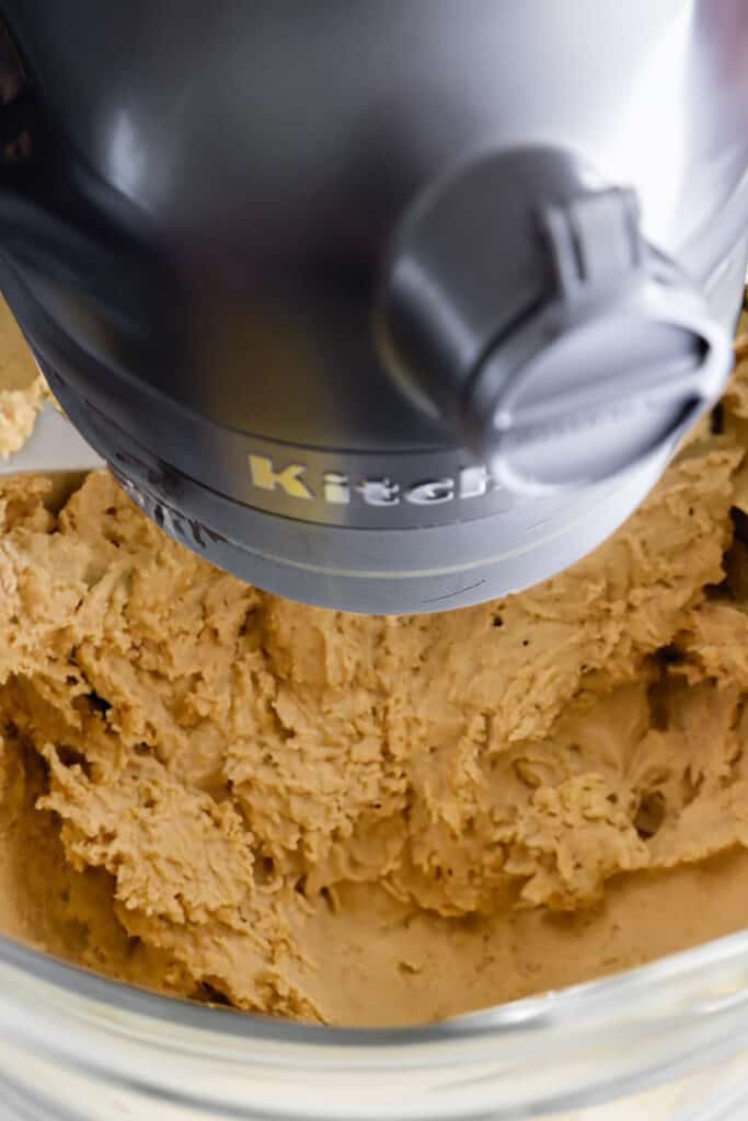 Peanut butter cookie dough in a KitchenAid stand mixer bowl.