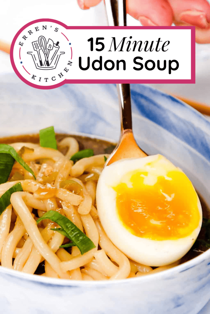 A bowl of soup with udon noodles, Japanese flavored broth and topped with scallions and a soft boiled egg.