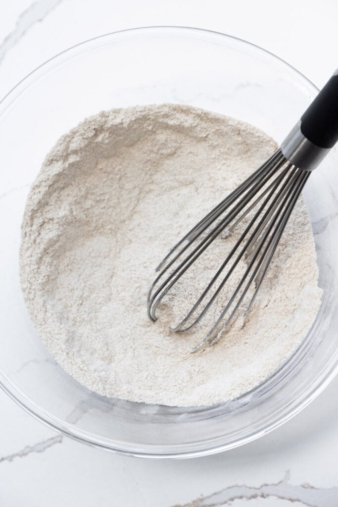 the dry ingredients for Zucchini Bread mixed in a glass bowl.