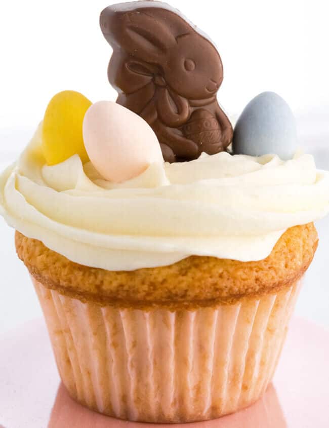 a cupcake with white frosting and easter candy on top