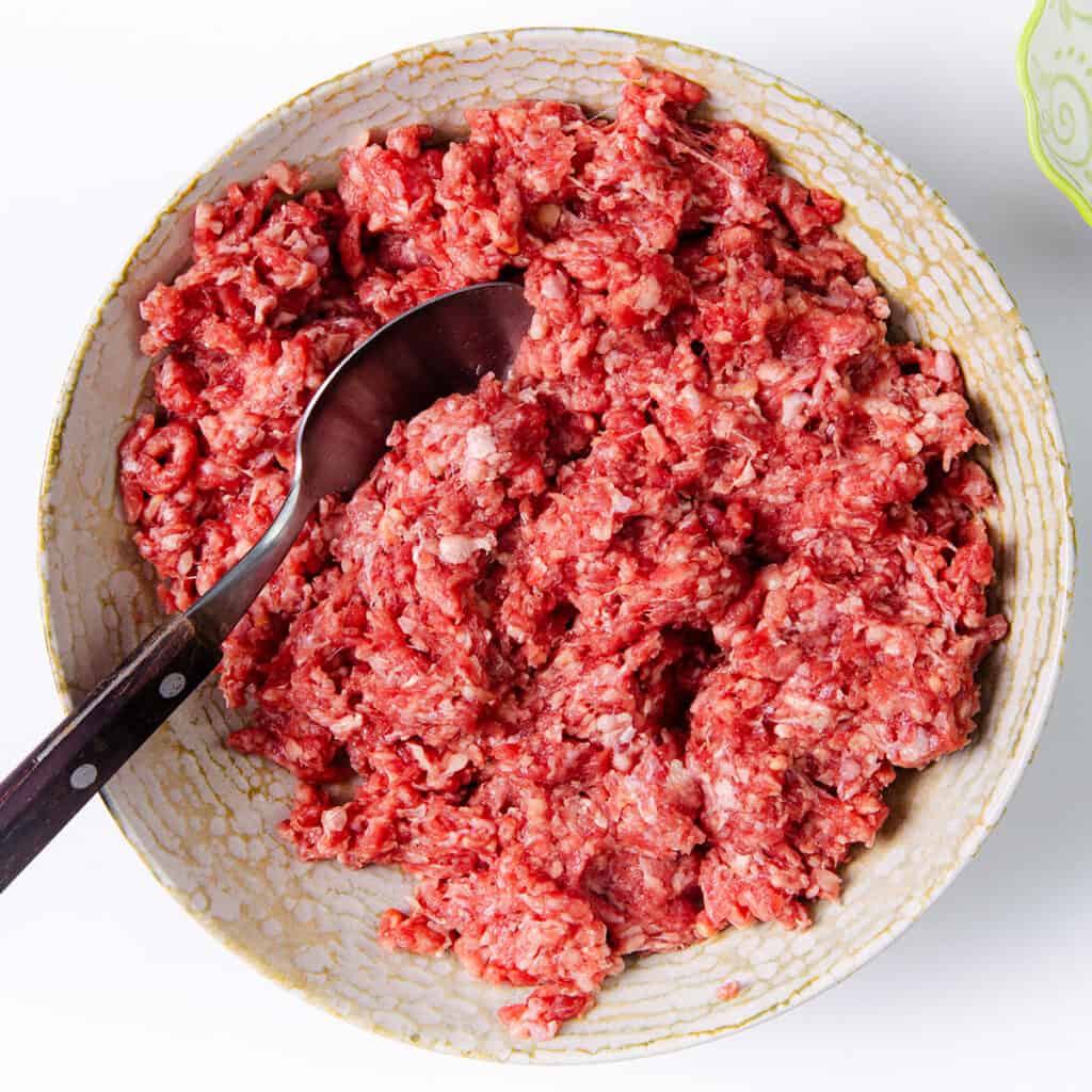 ground beef in a bowl with a spoon.