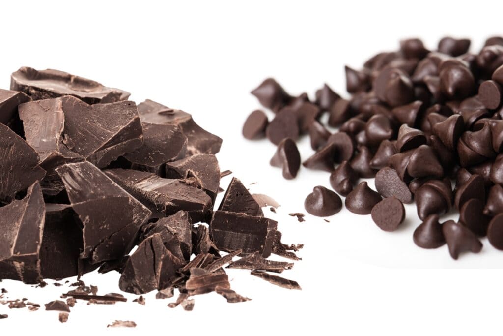 a close up image of chopped dark chocolate and a pile of chocolate chips.