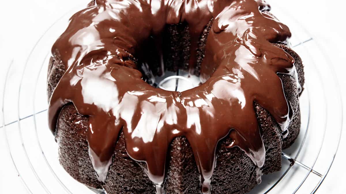 A moist chocolate bundt cake with chocolate frosting on a plate.