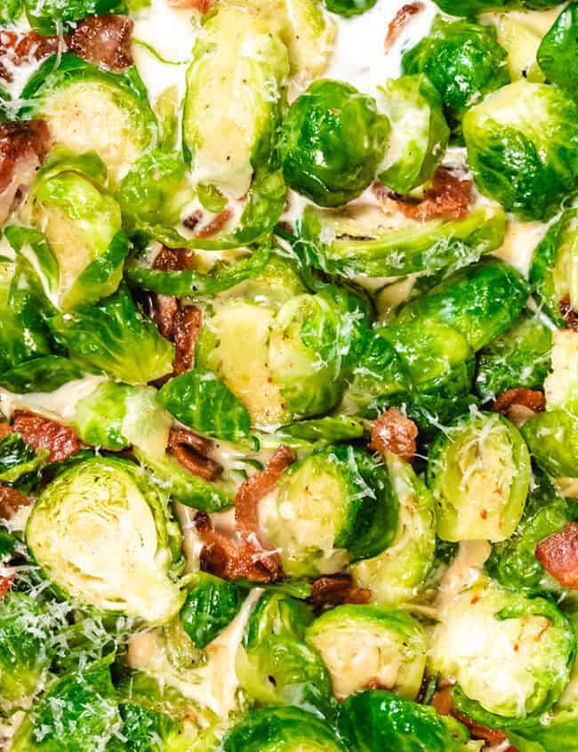 A pan with brussels sprouts and bacon in a cream sauce.