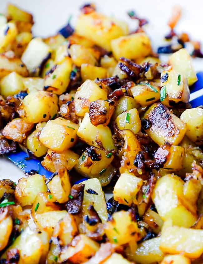 a close up image of Fried Potatoes and Onions in a skillet.