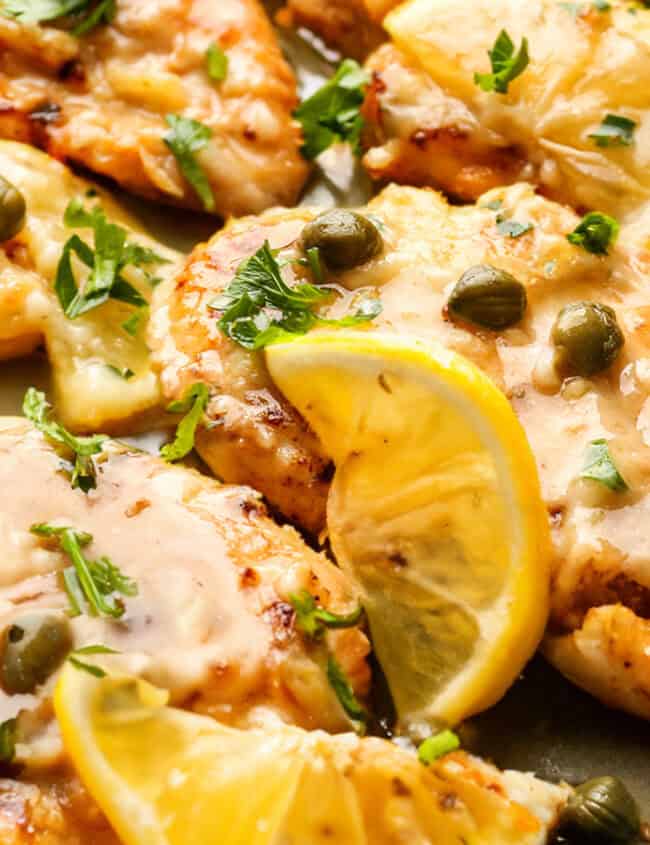 A plate of Fish Piccata garnished lemon and capers.