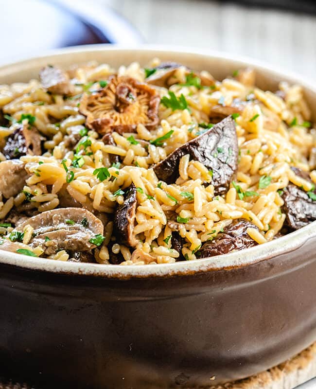 mushroom rice pilaf in a serving dish with the lid behind it