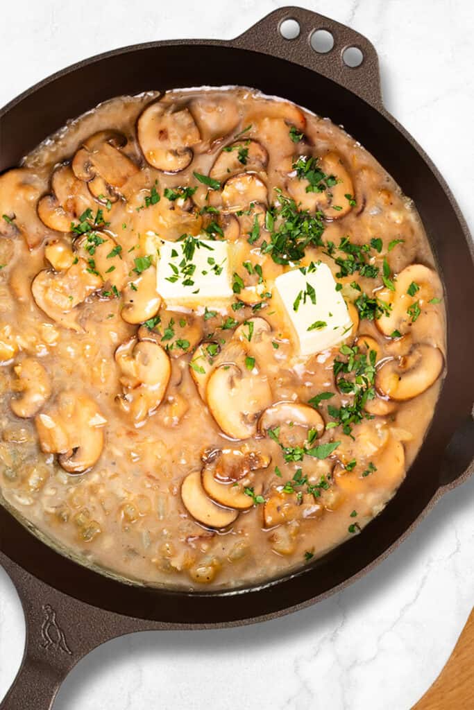 A Smythy Iron Ware skillet with marsala sauce cooking in it.