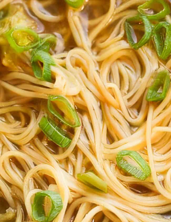 Chinese Noodle Soup in a bowl with sliced green onions on top.