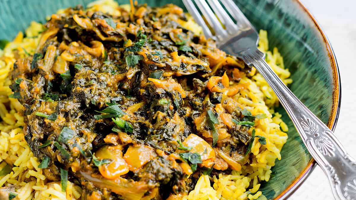 Sag Bahji {Spinach Curry} served over rice in bowl