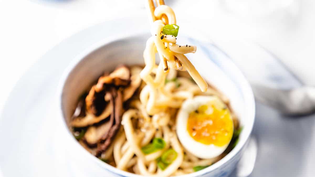 A photo of chopsticks holding noodles from Udon Soup