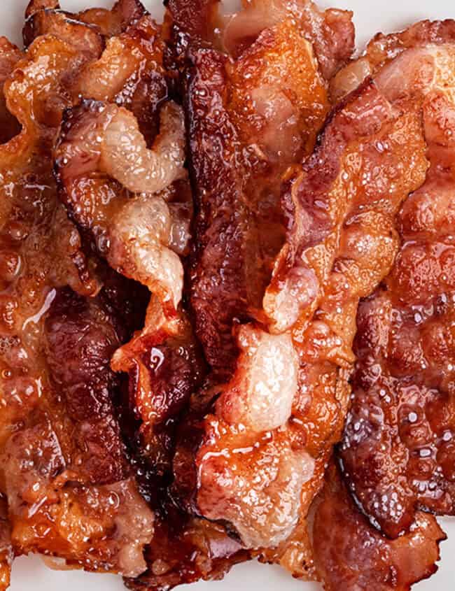 A close up image of crispy bacon on a plate.