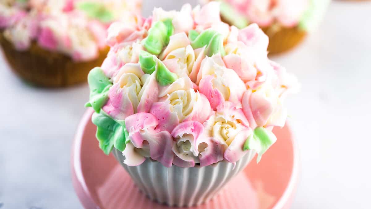 Cupcakes with frosting flowers on them.