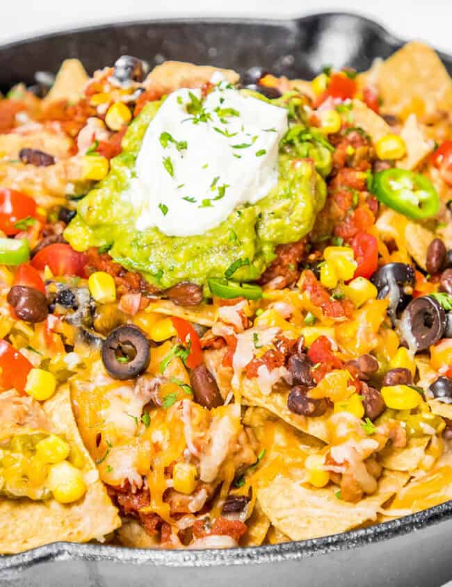 Hot nachos fresh from the oven topped with guacamole and sour cream.