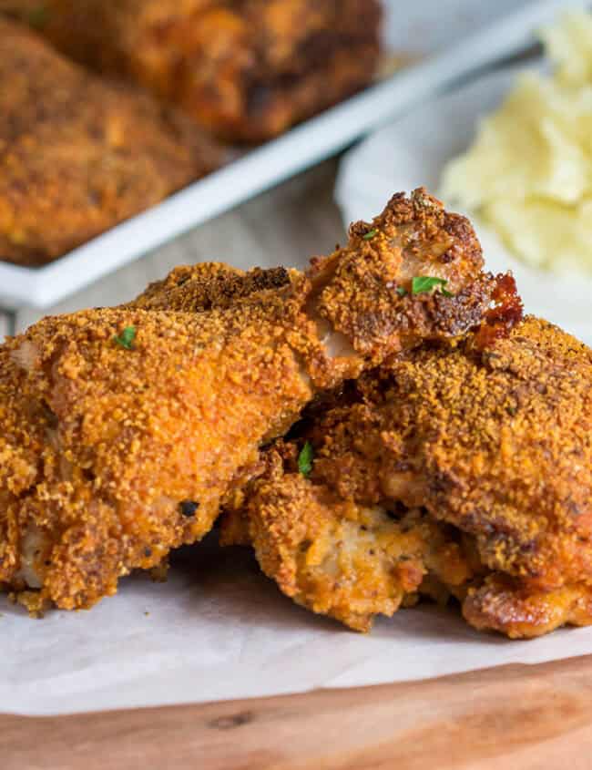 Three pieces of Easy Oven Fried Chicken speckled with parsley.