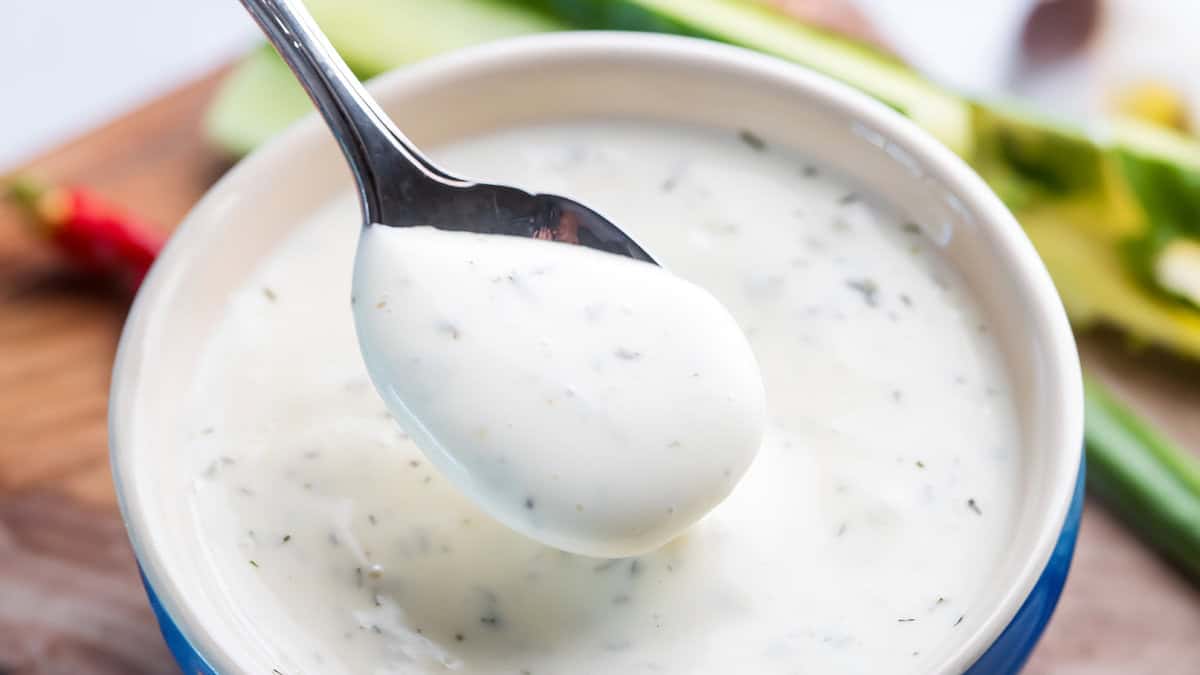 A closeup image of a spoonful of ranch dressing.