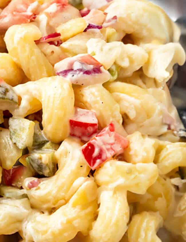 Amish Macaroni Salad in a bowl with a serving spoon.