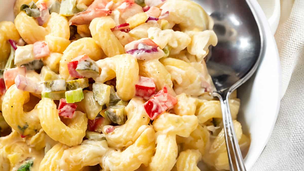 Amish Macaroni Salad in a bowl with a serving spoon.