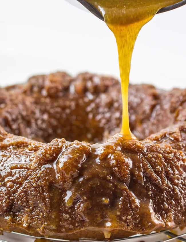 A cake with caramel sauce being poured over it.