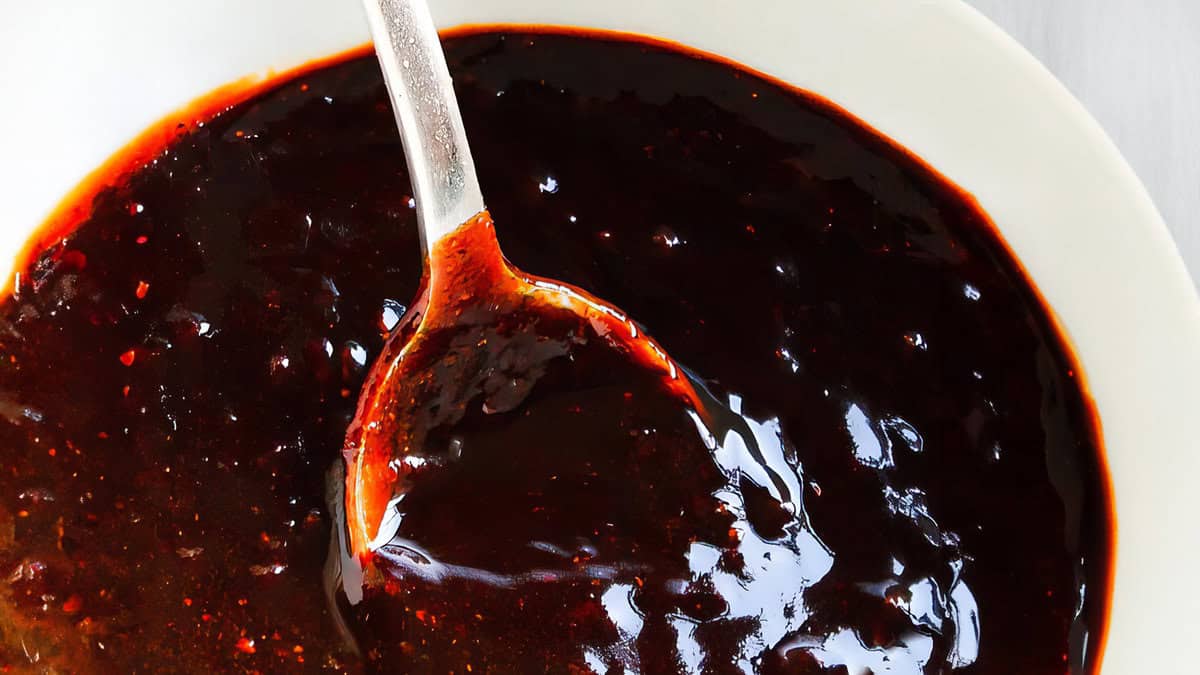 A close up image of a spoon in Carolina BBQ Sauce.