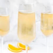 Three Champagne Cocktails with white marble background.