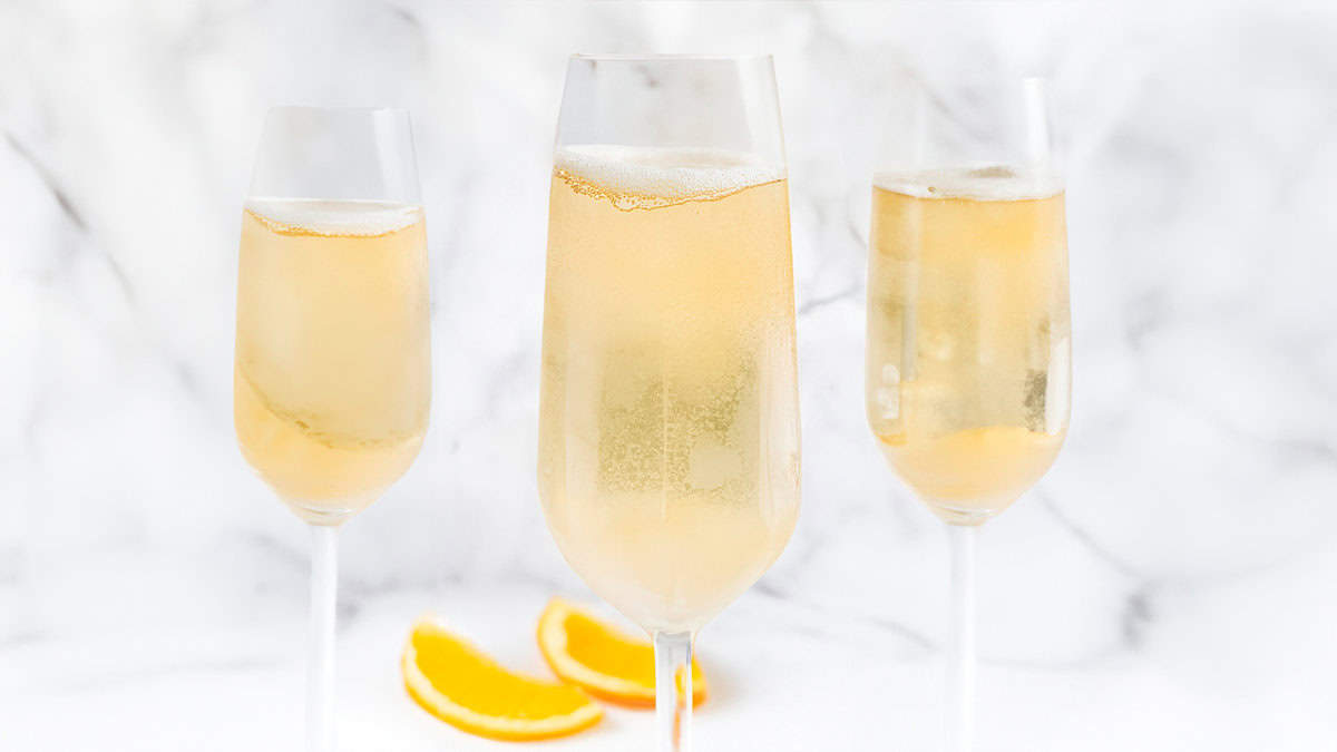 Three Champagne Cocktails with white marble background.