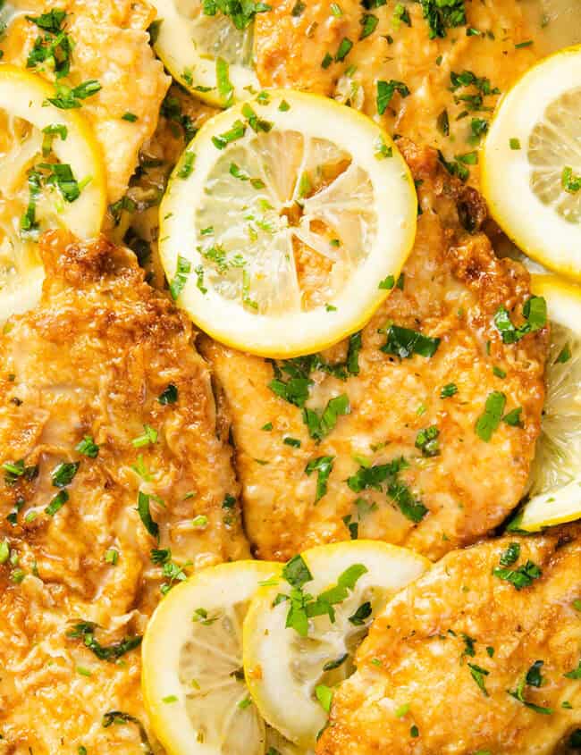 a close up image of Chicken Francaise in a black pan.