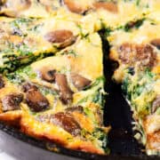 Spinach Mushroom Frittata in a pan sliced into wedges.