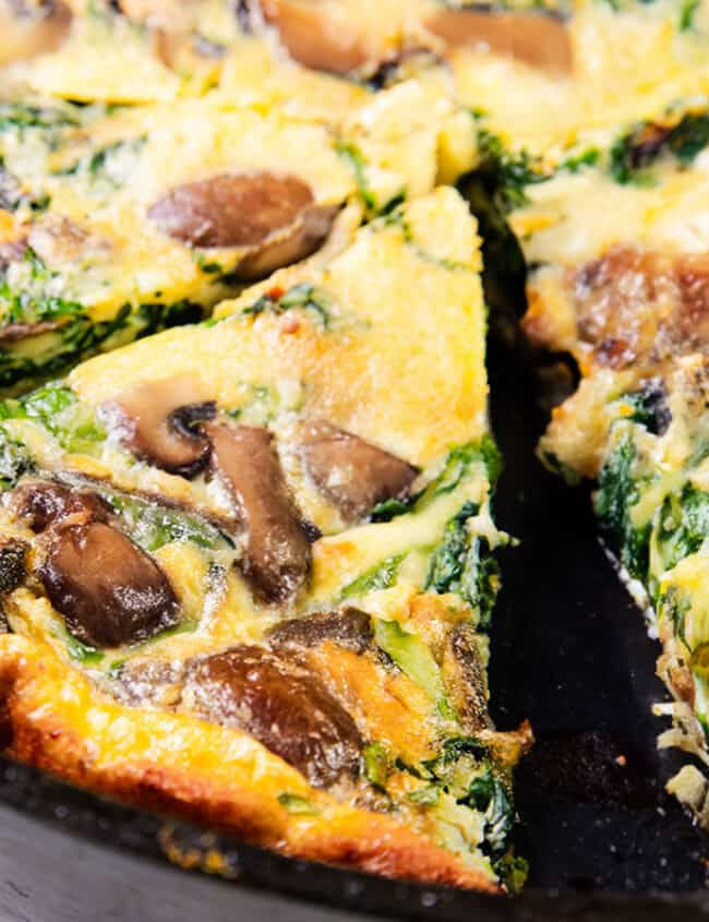 Spinach Mushroom Frittata in a pan sliced into wedges.