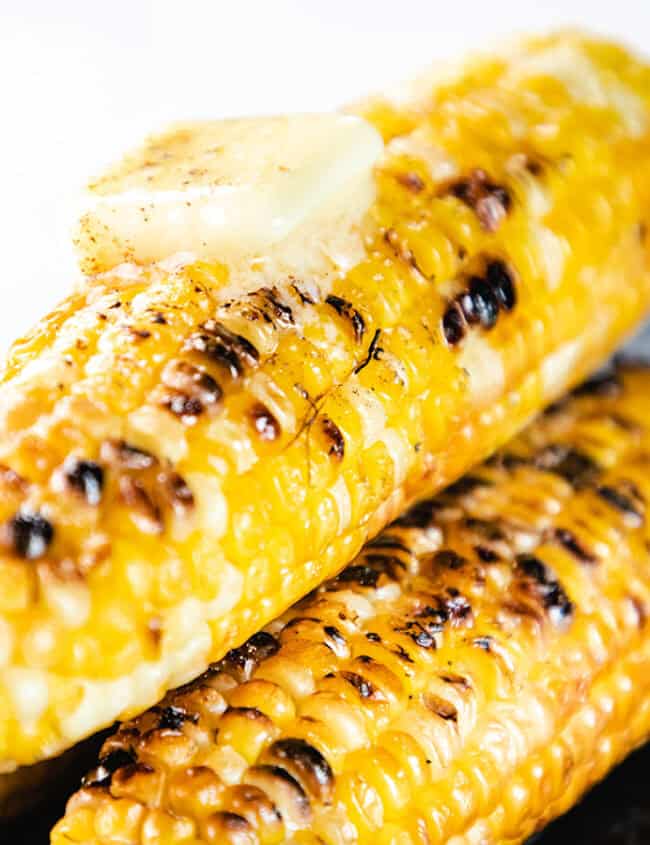 Grilled corn on the cob topped with butter, salt and pepper.