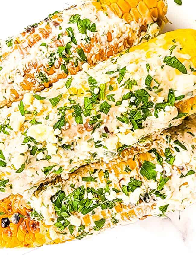 Mexican Street Corn covered in a sour cream sauce and crumbled cheese.