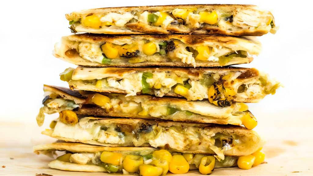 A close up image of Roasted Corn Quesadillas stacked in a pile.