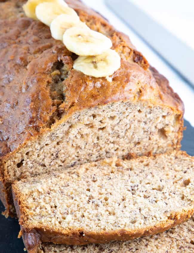 A banana bread loaf sliced and ready to eat.