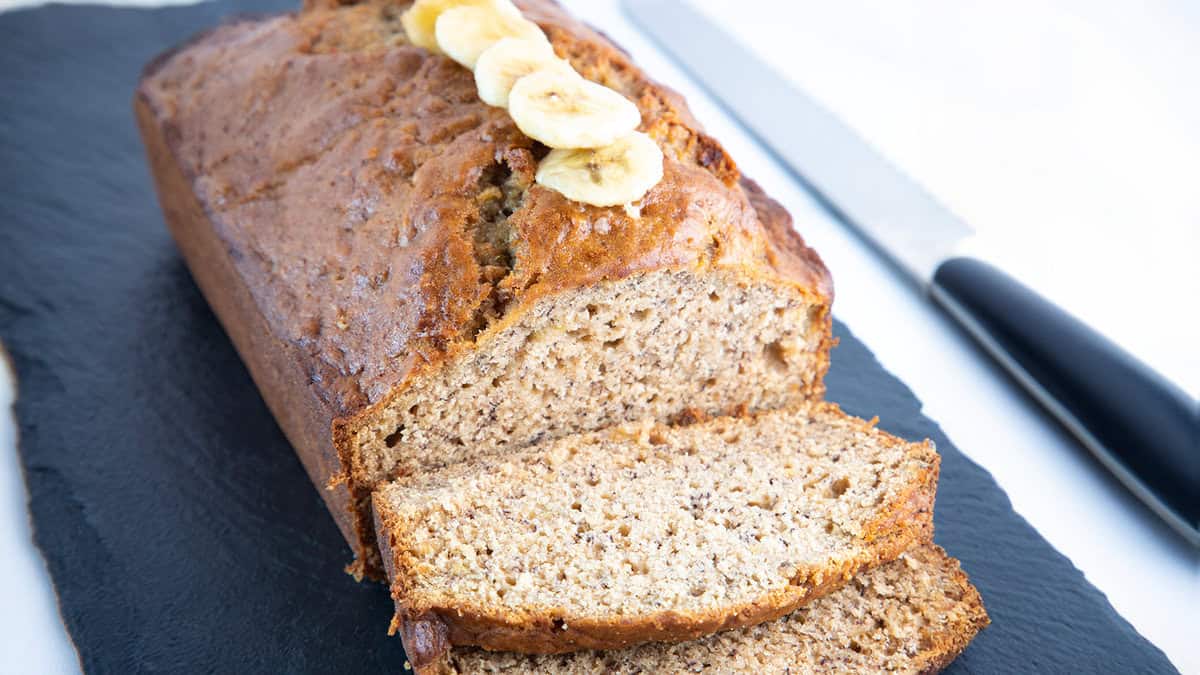 A banana bread loaf sliced and ready to eat.